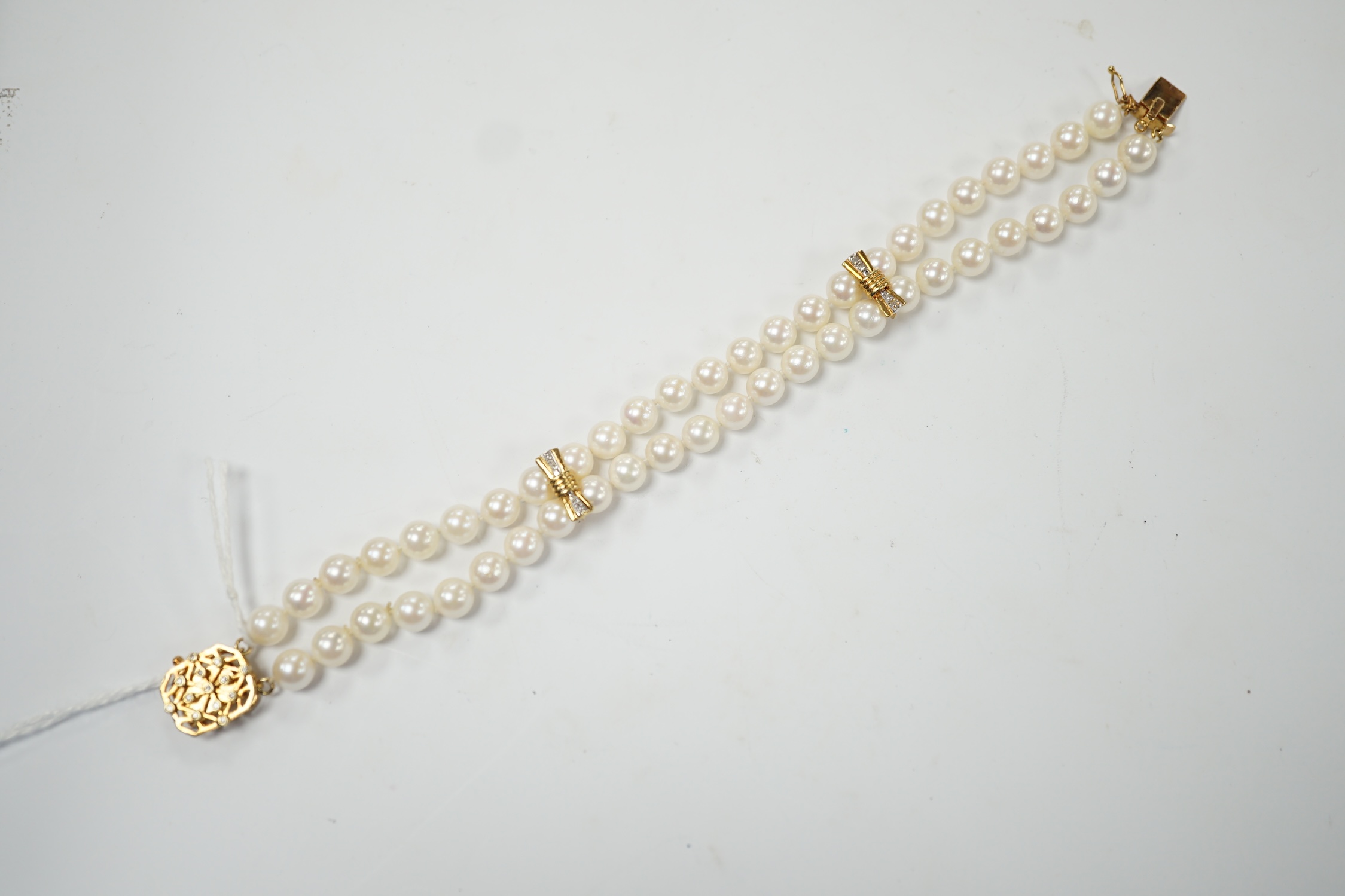 A double strand cultured pearl bracelet, with diamond chip set 14k clasp and spacers, 18cm. Condition - good